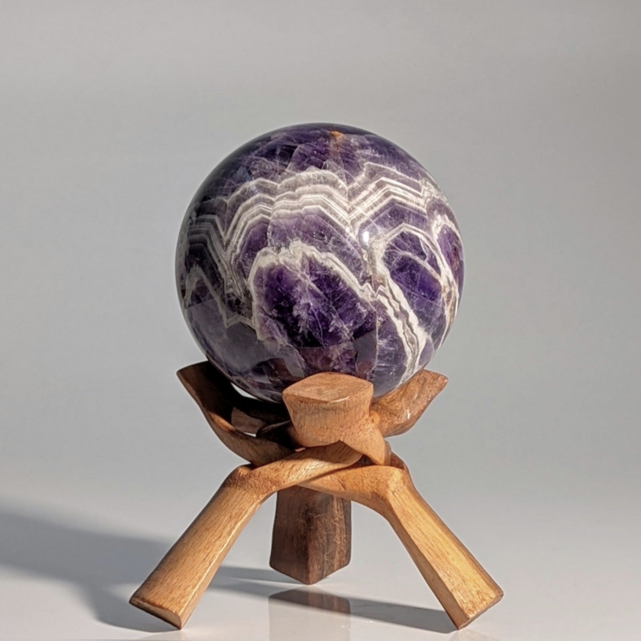 Deep Purple Chevron Amethyst Polished Sphere on Wooden Stand